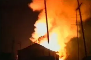 A fire is burning in the sky and some buildings are on fire.