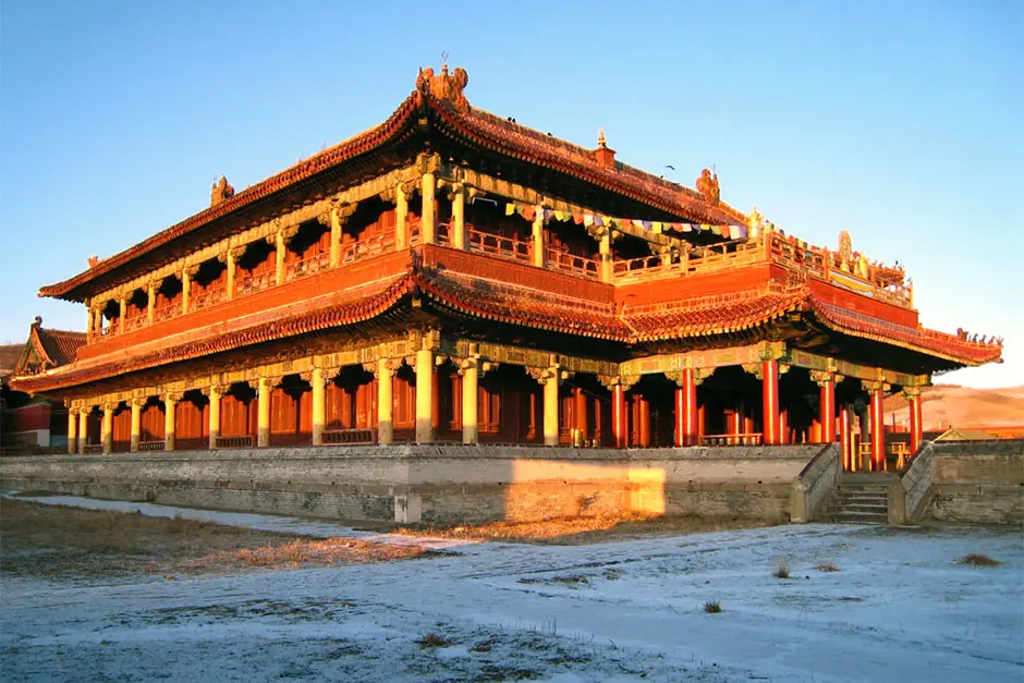 A large building with many windows and red roof.