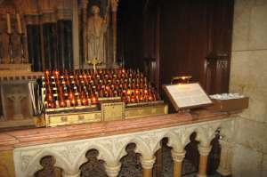 A church organ with candles on the top of it.