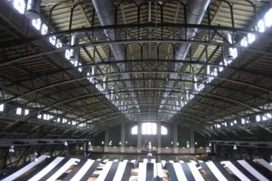 A large metal building with many lights on it.