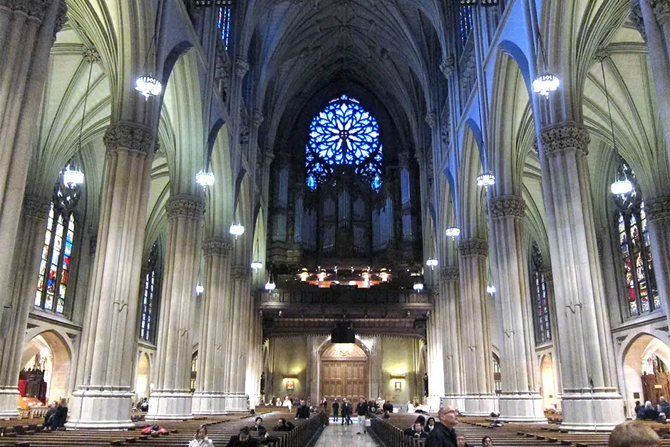 A cathedral with many people sitting in it